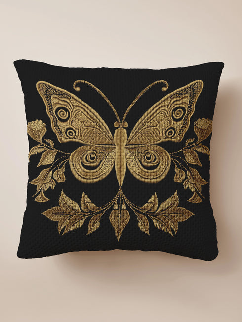 A black woven throw pillow featuring an embroidered gold Hamsa hand surrounded by intricate floral and botanical designs.